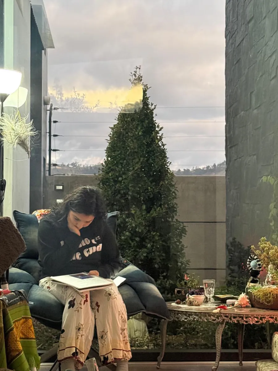 Mujer sentada leyendo su cuaderno al atardecer