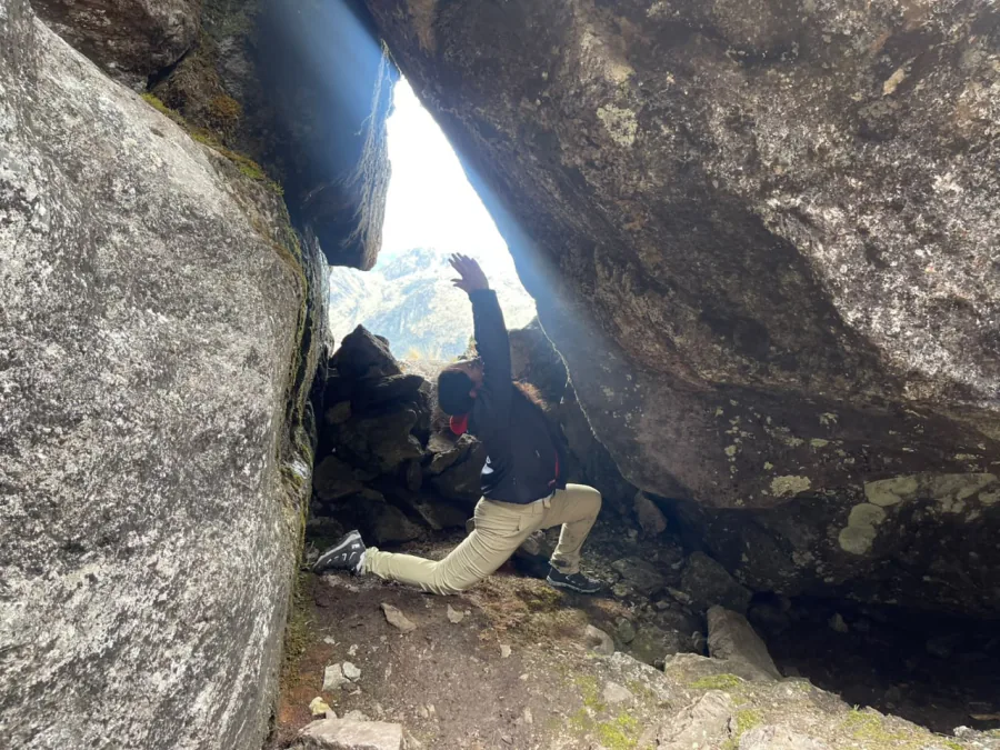 Practicando una postura de yoga entre rocas, iluminada por un haz de luz